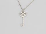 un pendentif en forme de clé, en or blanc et diamants, monté sur une chaîne