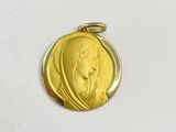 l'image d'une médaille d'or sur laquelle figure le visage d'une femme