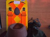 un chapeau posé sur un bureau, à côté d'un ordinateur portable et d'autres objets