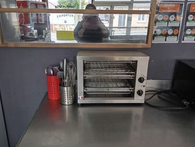 un four grille-pain posé sur un plan de travail devant une fenêtre