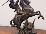 statue of a man on a horse with a sword on a wooden table