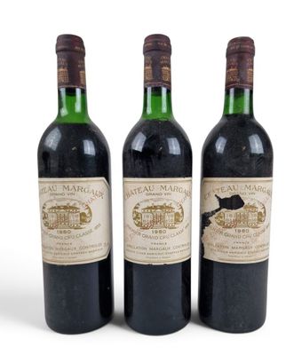 trois bouteilles de vin posées les unes à côté des autres sur une surface blanche
