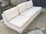 an image of a white couch sitting on a concrete slab