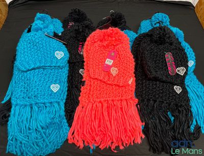 four different colors of knitted scarves on a black surface