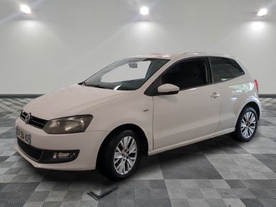 the white volkswagen polo is parked in a room with a checkered floor