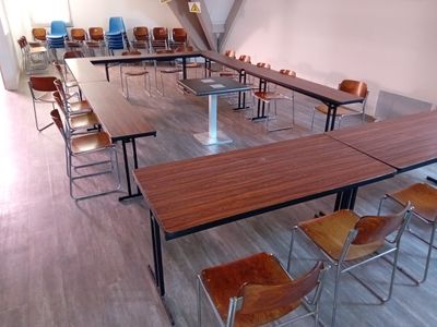 une longue table et des chaises dans une pièce avec un parquet