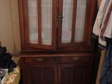 un meuble en bois avec une porte en verre dans une pièce
