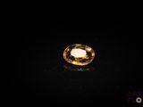a yellow sapphire stone on a black surface