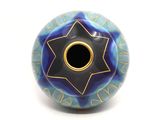 a blue and black vase with a star of david on it