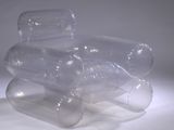 trois bouteilles en plastique vides empilées les unes sur les autres sur une surface blanche