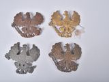 four different types of metal brooches on a white surface
