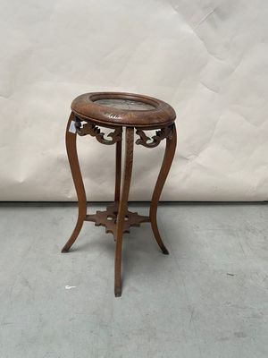 a small wooden table with a glass on top