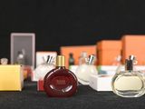 several bottles of perfume are lined up on a black surface