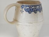 a blue and white cup sitting on a white surface