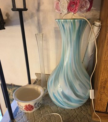a blue and white vase sitting on a table next to a cup
