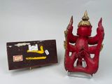 a red statue and a box on a white surface
