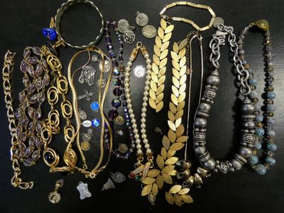 many different types of necklaces and bracelets on a table