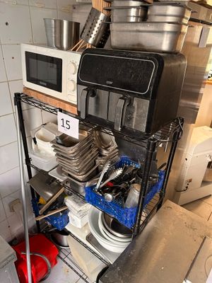 une étagère sur laquelle sont posés des casseroles et des poêles, dans une cuisine