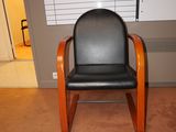 un fauteuil en cuir noir avec une structure en bois dans une pièce