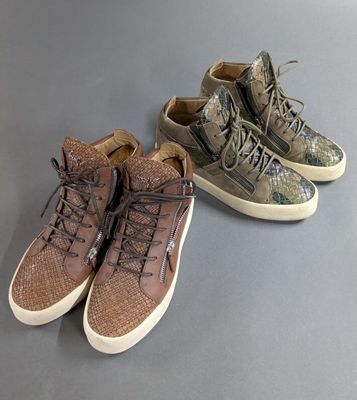 two pairs of shoes are lined up on a gray surface
