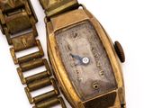 a gold wrist watch with a chain around it