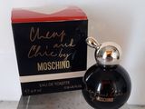 un flacon de parfum noir dans un coffret rouge, posé sur un comptoir en marbre
