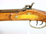 a close up of a rifle with a wooden handle and brass fittings