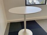 a small white table in a corner of a room