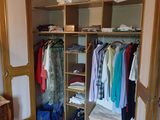 une photo d'une chambre avec une armoire remplie de vêtements