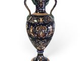 un vase bleu orné de motifs dorés sur fond blanc