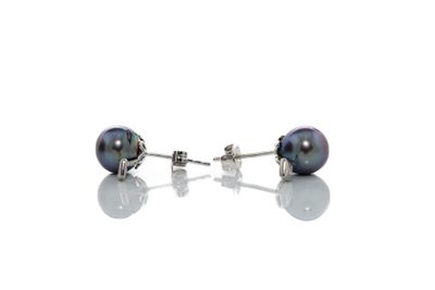 une paire de boucles d'oreilles en perles noires posées sur une surface blanche