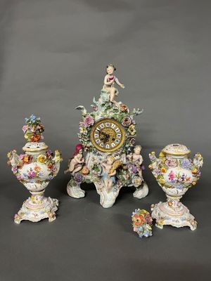 une horloge posée sur une table à côté de trois vases