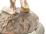 a bronze statue of a man standing on a rock