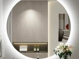 un grand miroir rond au-dessus d'un lavabo dans une salle de bains