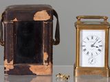une petite horloge posée à côté d'une petite boîte sur une table