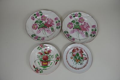 three plates with flowers on them sitting on a white surface