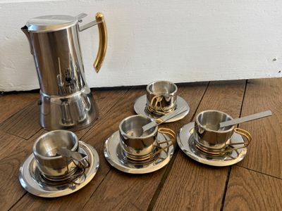 quatre tasses à café et une cafetière par terre