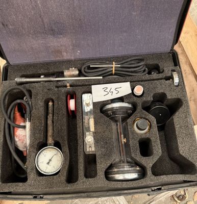 une mallette posée par terre, contenant des outils