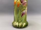 un vase vert orné de fleurs peintes