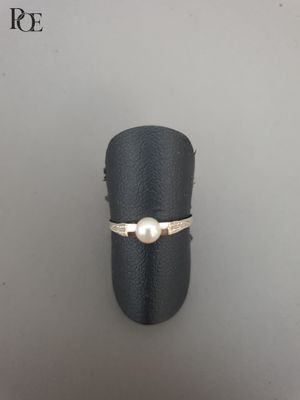 Gros plan sur une bague ornée d'une perle