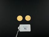 a close up of two gold coins on a black surface