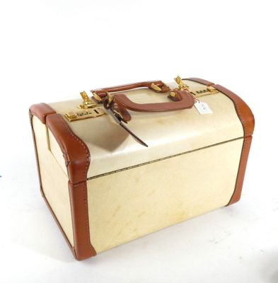 a small suitcase sitting on a white surface with a tag on it