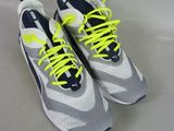 pair of white and grey sneakers with neon yellow laces on them