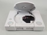 a white game console with a game controller in it