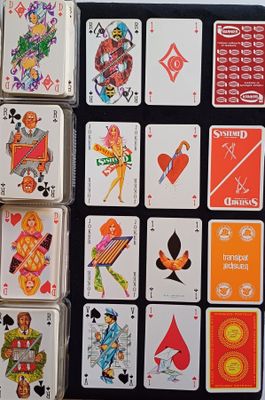 de nombreuses cartes à jouer posées sur une table, aux motifs très variés