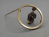 une photo d'une broche en or sertie de pierres violettes