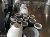 many cups and saucers sitting on the counter