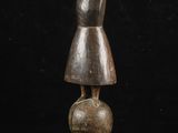 une statue en bois représentant une femme debout au sommet d'une boule