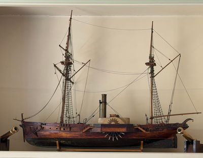 a model of a ship on a shelf in a room
