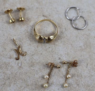 Trois paires de boucles d'oreilles et une bague sont posées sur une table